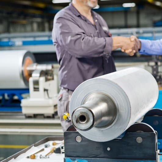 Händedruck in der Produktion vor einer Saueressig Prägewalze